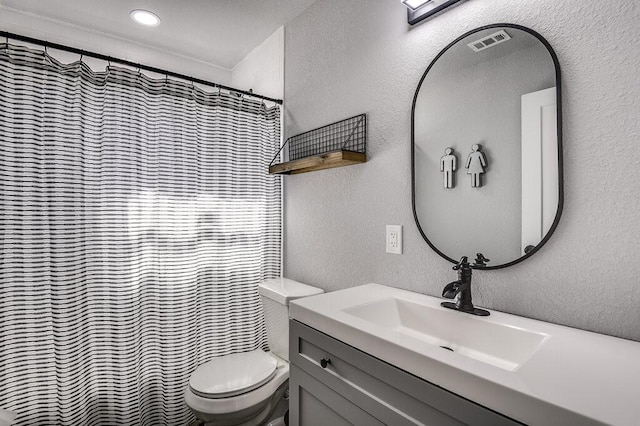 bathroom featuring walk in shower, vanity, and toilet