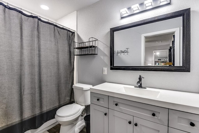 full bathroom featuring vanity, shower / bathtub combination with curtain, and toilet