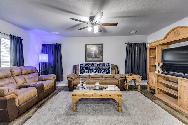 living room with ceiling fan, hardwood / wood-style flooring, and a textured ceiling