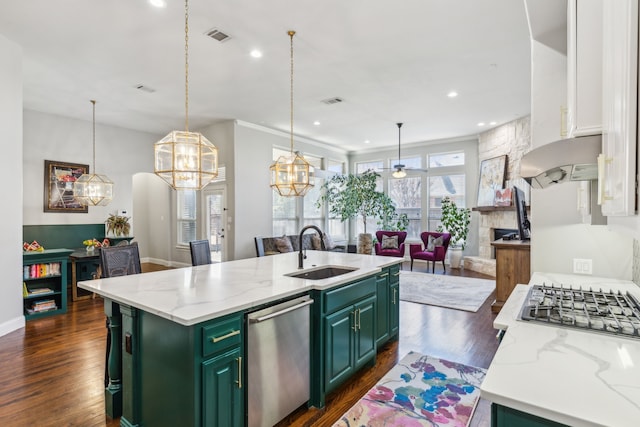 kitchen with sink, a kitchen island with sink, stainless steel dishwasher, green cabinets, and light stone counters