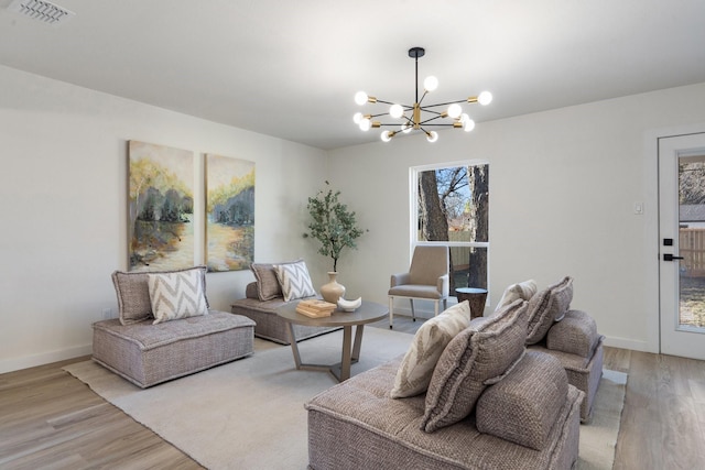 living room featuring light hardwood / wood-style floors and a chandelier