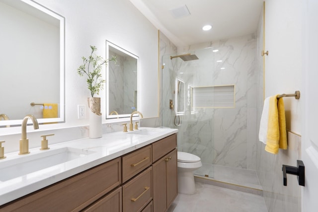 bathroom featuring vanity, a shower with shower door, and toilet