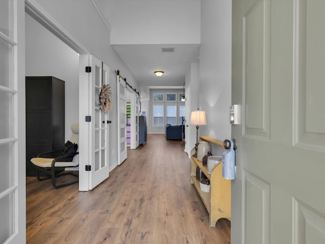 foyer entrance featuring wood-type flooring and a barn door