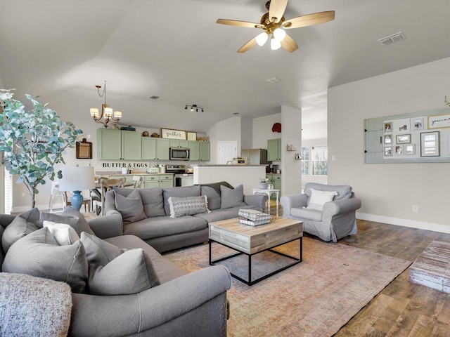 living room featuring hardwood / wood-style floors, ceiling fan with notable chandelier, and vaulted ceiling