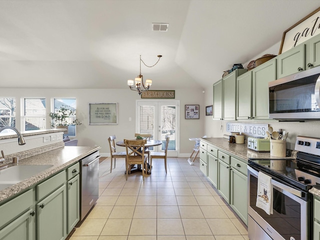 kitchen featuring appliances with stainless steel finishes, sink, hanging light fixtures, light tile patterned floors, and green cabinetry