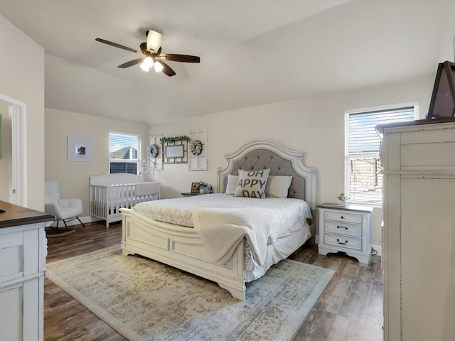 bedroom with dark hardwood / wood-style flooring, lofted ceiling, and ceiling fan