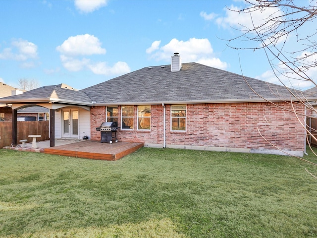 back of property featuring a wooden deck and a lawn