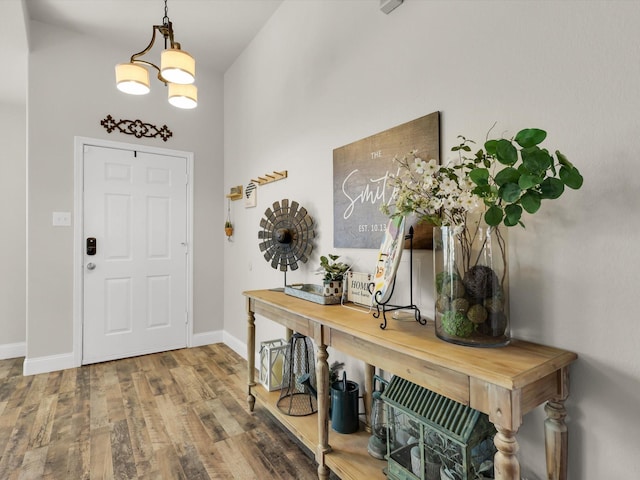 foyer entrance with hardwood / wood-style floors and a notable chandelier