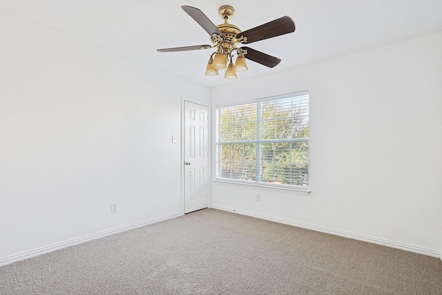 carpeted spare room with ceiling fan