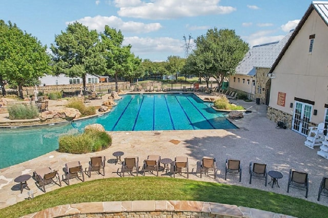 view of swimming pool featuring french doors