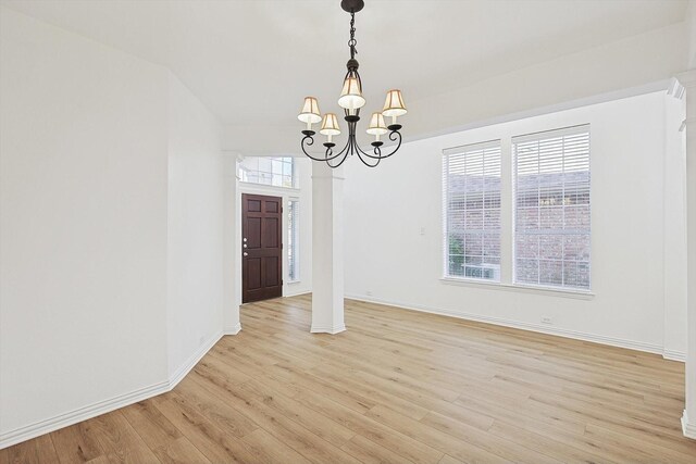 kitchen featuring sink, a center island, appliances with stainless steel finishes, light stone countertops, and light hardwood / wood-style floors