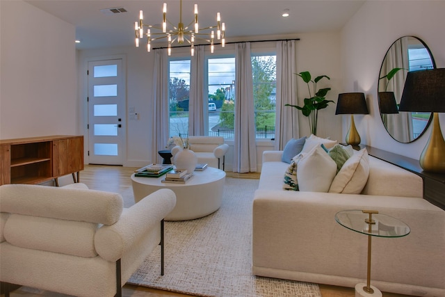 living room featuring an inviting chandelier and light hardwood / wood-style floors