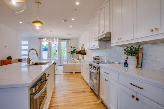 kitchen with white cabinetry, decorative light fixtures, and high end stainless steel range oven