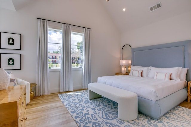 bedroom featuring multiple windows, vaulted ceiling, and light hardwood / wood-style floors