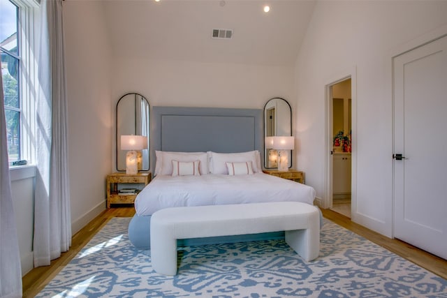 bedroom featuring lofted ceiling and light hardwood / wood-style flooring