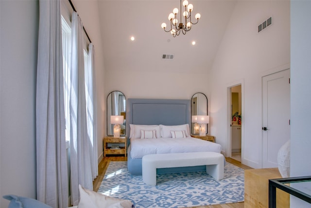 bedroom featuring an inviting chandelier, multiple windows, high vaulted ceiling, and light wood-type flooring