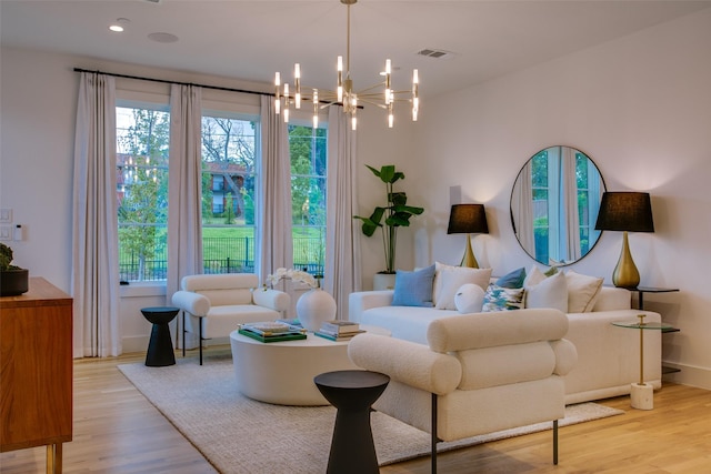 living room with an inviting chandelier and light hardwood / wood-style floors