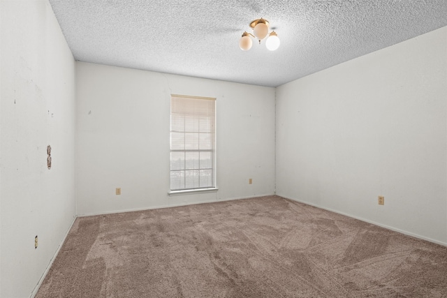 carpeted empty room with a textured ceiling