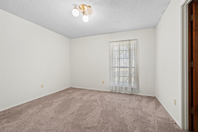 carpeted empty room with a textured ceiling