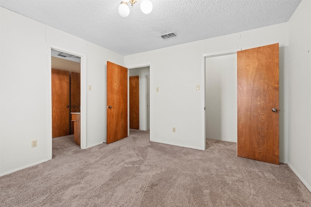 unfurnished bedroom featuring light carpet, a textured ceiling, and a closet