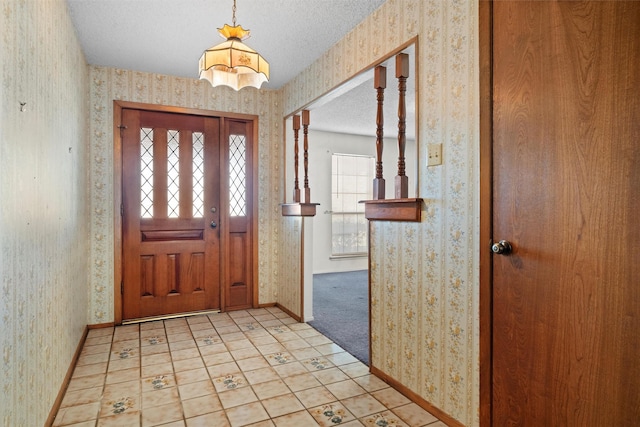 entrance foyer with light carpet and a textured ceiling