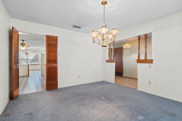 spare room featuring light carpet, ceiling fan with notable chandelier, and a textured ceiling