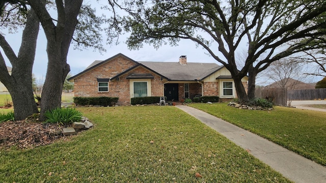 ranch-style house with a front yard, a chimney, fence, and brick siding