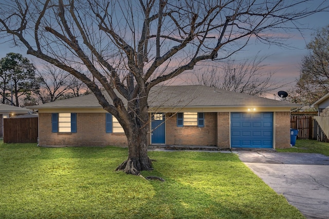 ranch-style house with a garage and a lawn