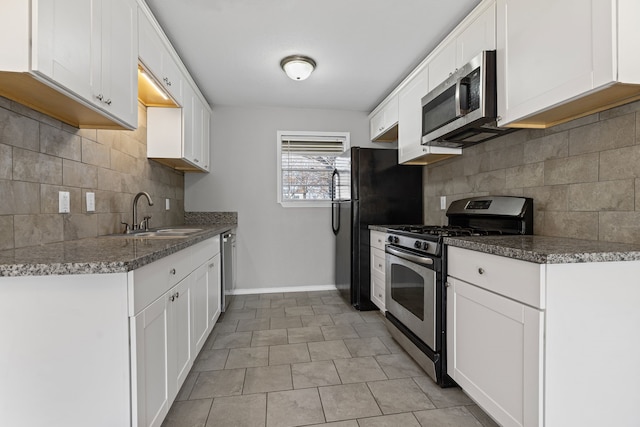 kitchen with appliances with stainless steel finishes, sink, and white cabinets