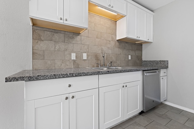 kitchen featuring tasteful backsplash, white cabinetry, dishwasher, sink, and tile patterned floors