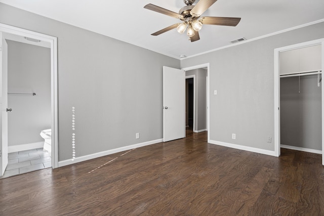 unfurnished bedroom featuring dark hardwood / wood-style floors, connected bathroom, ornamental molding, a spacious closet, and ceiling fan