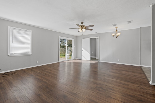 empty room with dark hardwood / wood-style floors and ceiling fan with notable chandelier