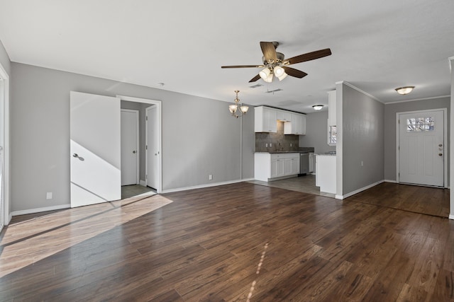 unfurnished living room featuring ceiling fan with notable chandelier, dark wood-type flooring, and ornamental molding