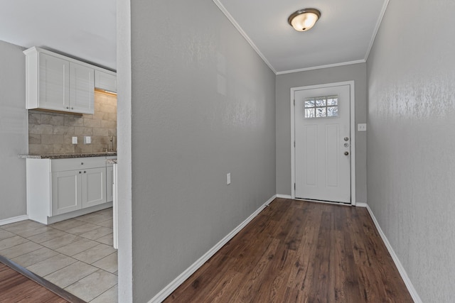 entryway with ornamental molding and light wood-type flooring