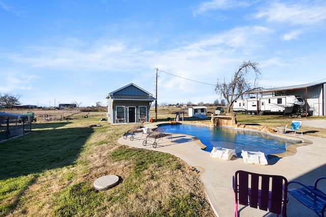 view of swimming pool with an outdoor structure, a patio area, and a lawn