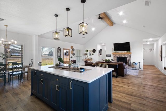 kitchen with a center island, blue cabinetry, dark hardwood / wood-style flooring, and decorative light fixtures