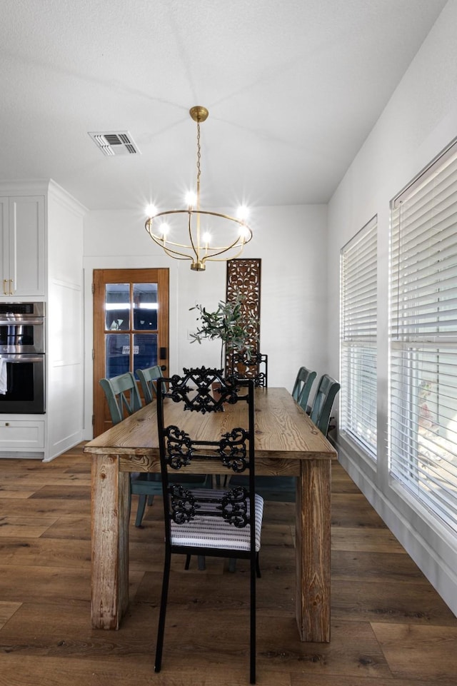 dining area with dark hardwood / wood-style flooring and a chandelier