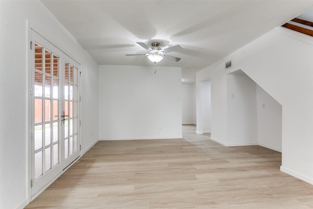 empty room featuring a textured ceiling, ceiling fan, and light wood-type flooring