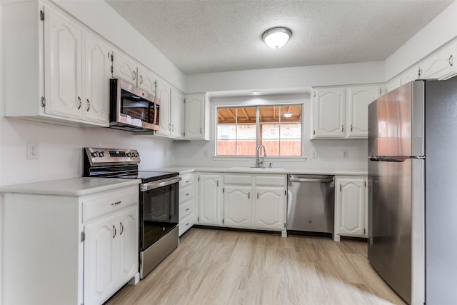 kitchen with white cabinetry, sink, a textured ceiling, and appliances with stainless steel finishes