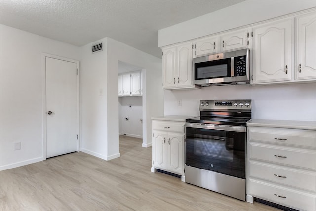 kitchen with white cabinetry, stainless steel appliances, a textured ceiling, and light wood-type flooring