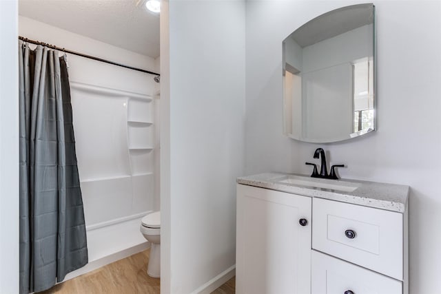 bathroom with toilet, a shower with curtain, a textured ceiling, vanity, and hardwood / wood-style floors