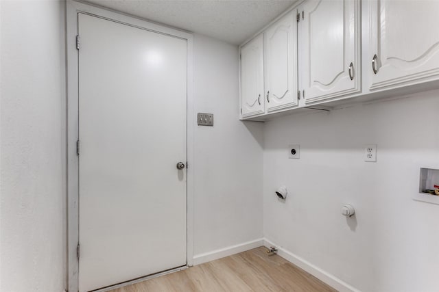 clothes washing area featuring gas dryer hookup, cabinets, washer hookup, light hardwood / wood-style floors, and electric dryer hookup