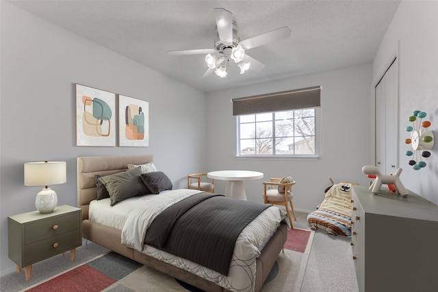 bedroom with ceiling fan, a closet, and a textured ceiling