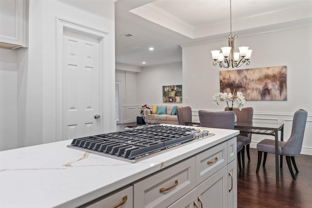 kitchen with decorative light fixtures, a tray ceiling, ornamental molding, stainless steel gas stovetop, and dark wood-style floors