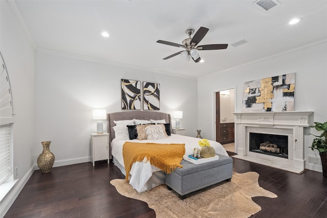 bedroom featuring visible vents, crown molding, baseboards, a premium fireplace, and hardwood / wood-style flooring