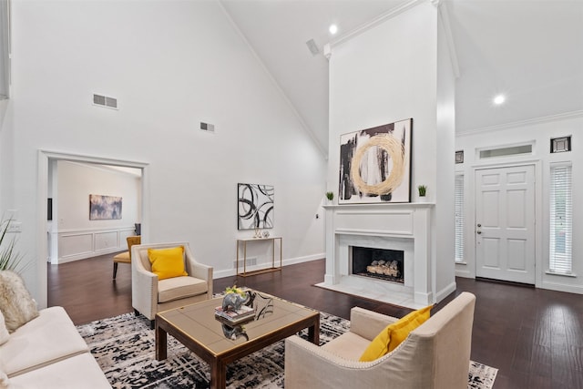 living area featuring wood finished floors, a fireplace, visible vents, and ornamental molding