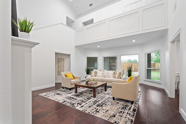 living room featuring crown molding, a towering ceiling, and dark hardwood / wood-style flooring