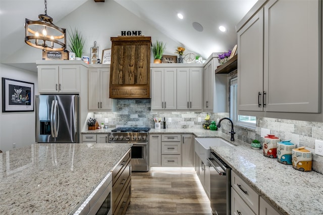 kitchen with pendant lighting, tasteful backsplash, lofted ceiling with beams, stainless steel appliances, and light stone countertops