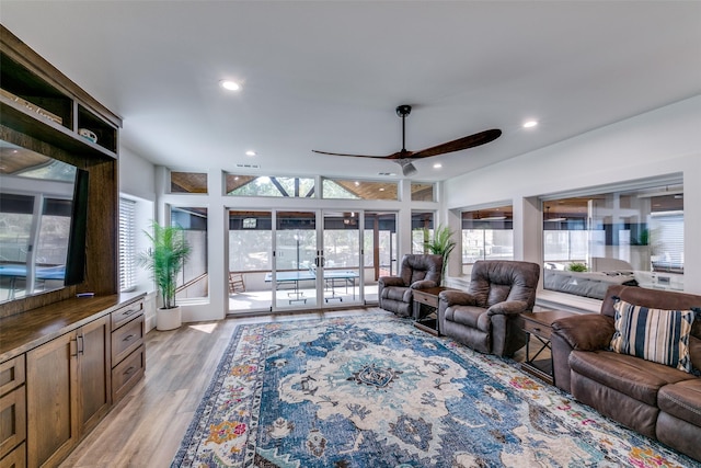 living room featuring ceiling fan and light hardwood / wood-style flooring