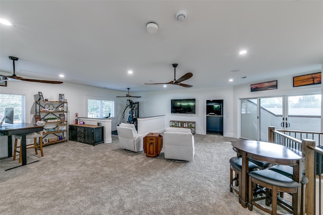 living room with a wealth of natural light, light carpet, and ceiling fan